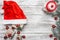 Upper, top view, of Christmas presents and santa hat on a wooden rustic background, evergreen, pins and toys.