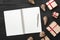 Upper, top view, of Christmas presents on a wooden black rustic background, note pad.