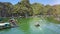 Upper View Boat Drifts on Calm Bay to Floating Village by Island