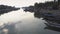 Upper view fishing boats on river reflecting white clouds