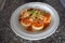 Upper view of one plate of sorrentinos - stuffed pasta - with sauce, parmesan cheese, and decorated with some parsleyÂ´s leaves