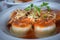 Upper view of one plate of sorrentinos - stuffed pasta - with sauce, parmesan cheese, and decorated with some parsleyÂ´s leaves