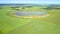 Upper view round lake among vast green fields