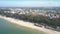 Upper view sandy beach with tents by ocean against houses