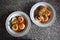 Upper view of two plates of sorrentinos - stuffed pasta - with sauce, parmesan cheese, and decorated with some parsleyÂ´s leaves