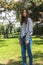 Upright vertical portrait of a Latina brunette teen girl looking at camera in a park