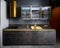 Upscale flat design kitchen with induction black glass hob with cylinder golden extractor hood with marble stoneware