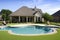 upscale ranch house with manicured lawn, swimming pool, and gazebo