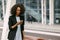 Upset afro-american woman is looking at the mobile phone. Close-up portrait.