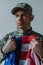 upset American soldier holding flag of