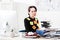 Upset attractive businesswoman sitting with stickers on face and clothes in office, looking