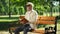 Upset blind retired man bored with braille book, feeling depressed alone in park