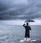 Upset business man holding a umbrella with cloudburst