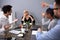 Upset Businesswoman Sitting With Colleague In Meeting