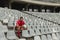 Upset Caucasian male rugby player sitting with rugby ball in stadium