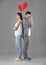 Upset couple and illustration of broken heart on grey background. Relationship problems