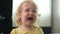 Upset curly haired child crying, portrait. capricious blonde girl in yellow T-shirt is furious and demands attention to