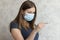 Upset, displeased girl in medical face mask with thermometer. Flu, cold, virus, fever and coronavirus symptoms. Woman measured her