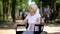 Upset elderly woman sitting in wheelchair at nursing home park, terminal illness