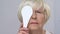 Upset elderly woman squinting eyes on ophthalmological examination, disorder