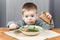 Upset face of little boy at the plate with soup