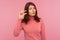 Upset frustrated woman with brown hair in pink sweater showing small size with her fingers, sceptic about centimeter inch size,