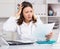 Upset girl doctor in uniform with papers at laptop in hospital