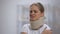 Upset girl in foam cervical collar suffering pain in back and shoulder, injury