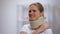 Upset girl in foam cervical collar suffering pain in shoulder, accident injury