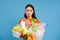 Upset girl has to recycle, holds plastic bottles and litter, looking bothered and angry, blue background