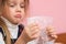 Upset girl pouting cheeks eats bubbles packaging film