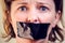 Upset girl with self-adhesive tape over her mouth. Kidnapping concept