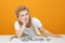 Upset girl sitting at table, propped her head on her hand, crumpled money lie in front of her on table