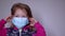 Upset little blonde girl in a blue medical mask. in a pink sweater. covid 19 pandemia. kids on isolation. FullHD footage