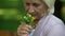 Upset mature woman looking at bouquet of field flowers in her arms, memories