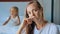 Upset mother with angry little child screaming pillow on the background