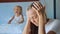 Upset mother with angry little child screaming pillow on the background