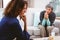 Upset mother discussing with daughter while sitting on sofa