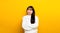 upset Portrait of an Asian girl Casual upset with folded arms looking out lonely. on a yellow background