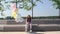 Upset redhead young woman sitting on bench with large fountain of colorful balloons outside.