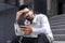 Upset and sad hindu businessman sitting on stairs outside office building, disappointed man reading online news using