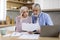 Upset Senior Spouses Reading Papers While Calculating Family Budget In Kitchen