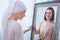 upset sick woman in kerchief standing near mirror with smiling reflection