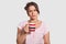 Upset sleepy lovely young woman holds cup of coffee, drink refreshing beverage to feel brave early in morning, dressed in casual c