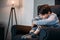 Upset thoughtful boy sitting in armchair and looking away at home