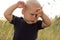 Upset toddler stands in the wheat field at sunset