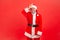 Upset unlucky elderly man with gray beard wearing santa claus costume showing looser gesture holding finger near forehead,