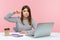 Upset woman office worker showing stupid gesture with finger looking at camera with displeased tired expression, sitting at