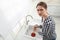 Upset woman using plunger to unclog sink drain in kitchen, above view