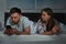 Upset young couple with smartphones in bed